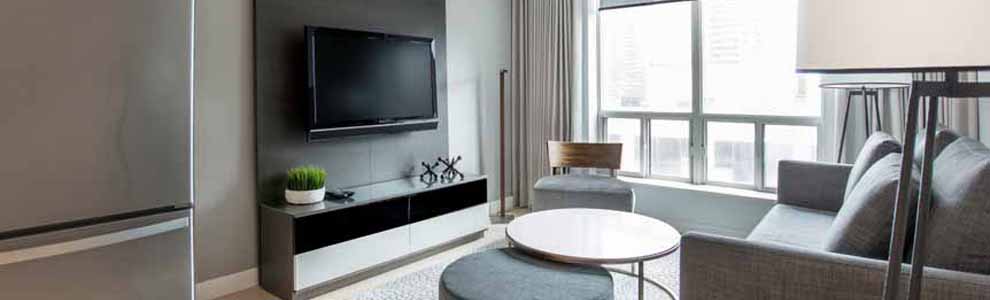 small apartment with big windows and grey couch