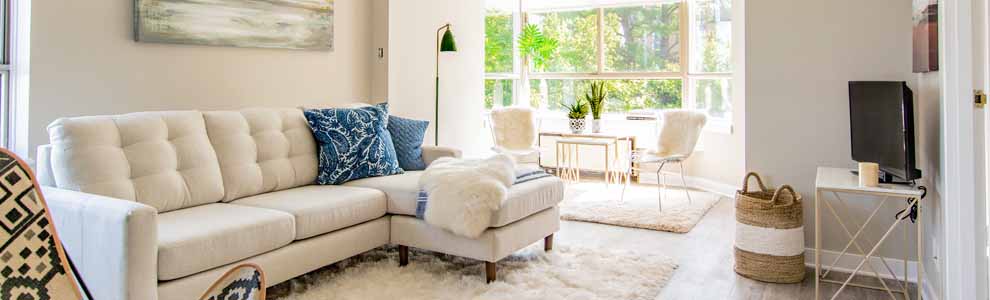 small apartment with white fluffy carpet and beige sofa
