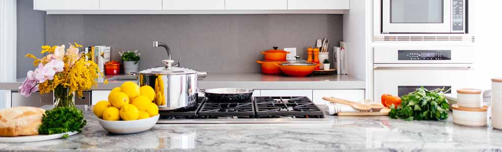 white kitchen with fruit and vegetables on the marble counter