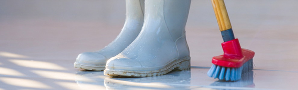 girl sweeping in blue rubber boots