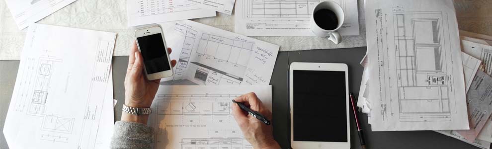 person at desk with smart phone, bills and papers doing bills