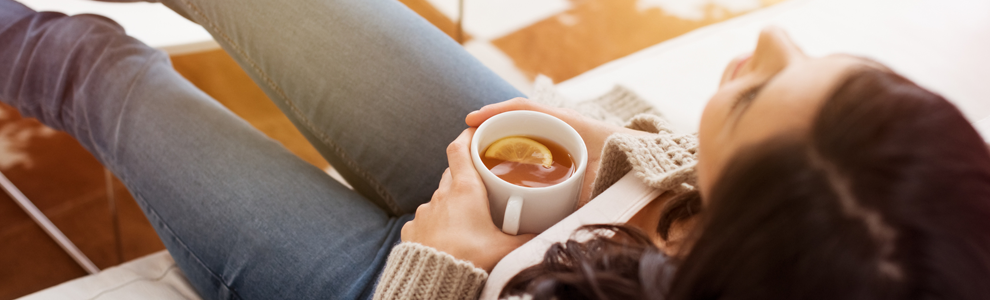 woman relaxing on a couch with a cup of tea