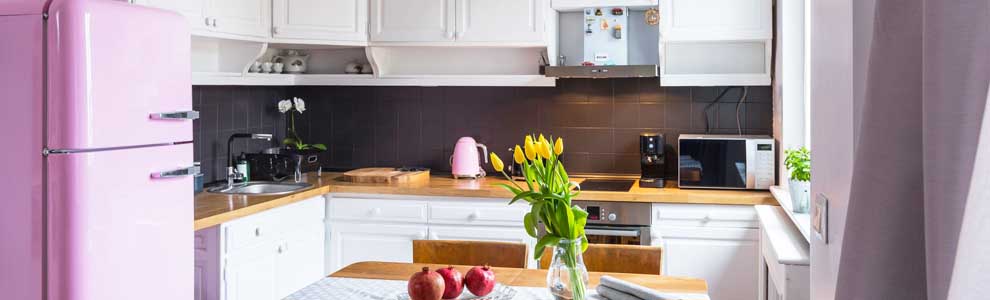kitchen with pink fridge and yellow tulips on table