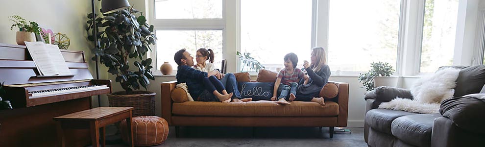 family of four on brown couch in comfortable living room