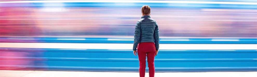 Person standing on the subway platform with train passing by