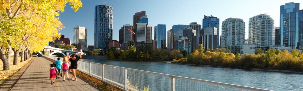 Family walking on trail beside river in Calgary