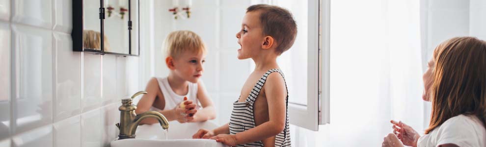 kids in white jack and jill bathroom brushing teeth